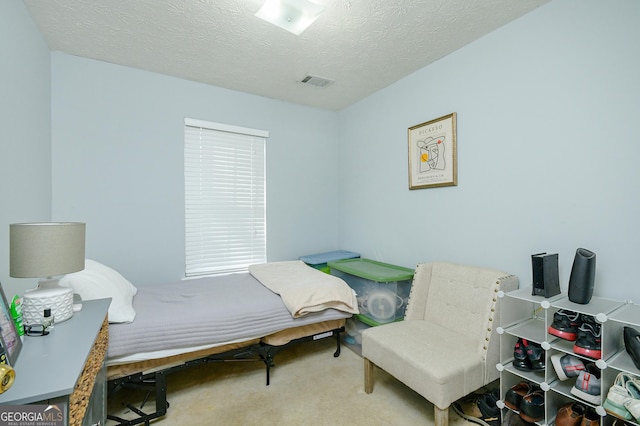 bedroom featuring carpet flooring and a textured ceiling