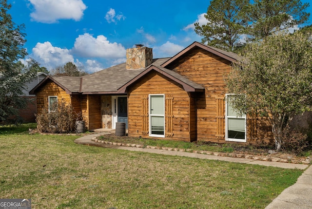 view of front of home featuring central air condition unit, a chimney, and a front lawn