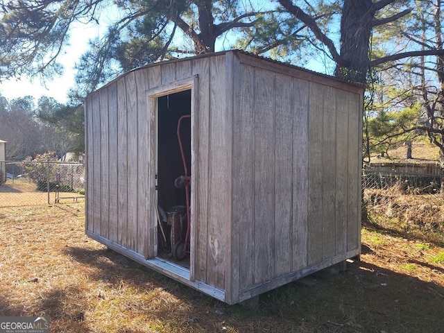 view of shed featuring fence