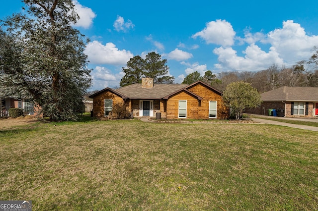 view of front of home with a chimney and a front lawn