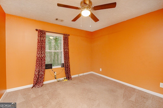 spare room featuring ceiling fan, carpet flooring, and a textured ceiling