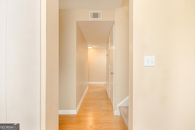 corridor with light hardwood / wood-style flooring