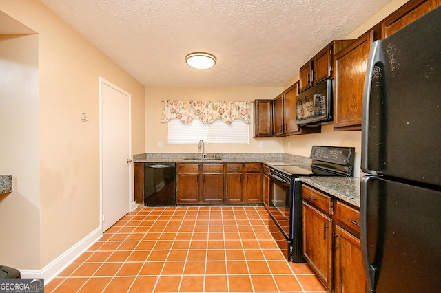 kitchen featuring sink, light tile patterned floors, a textured ceiling, and black appliances