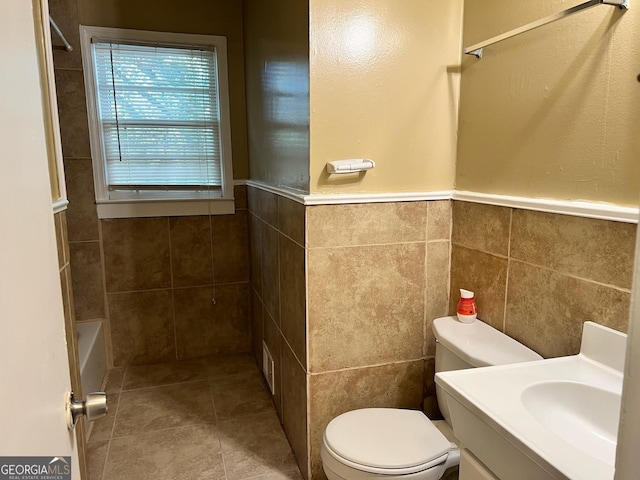 full bathroom featuring vanity, tile walls, toilet, and shower / bath combination