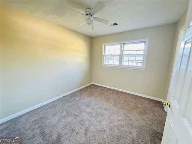 carpeted spare room featuring ceiling fan