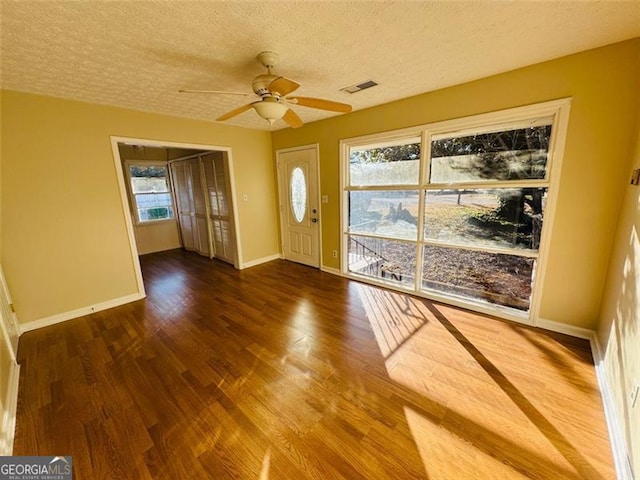 foyer entrance featuring ceiling fan, dark hardwood / wood-style floors, and a textured ceiling