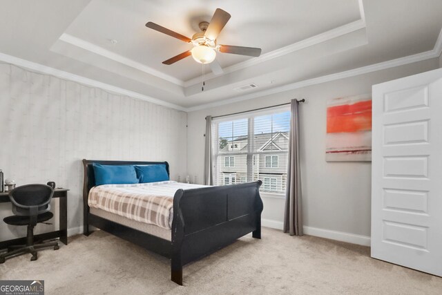 carpeted bedroom with a raised ceiling, crown molding, ceiling fan, and a closet