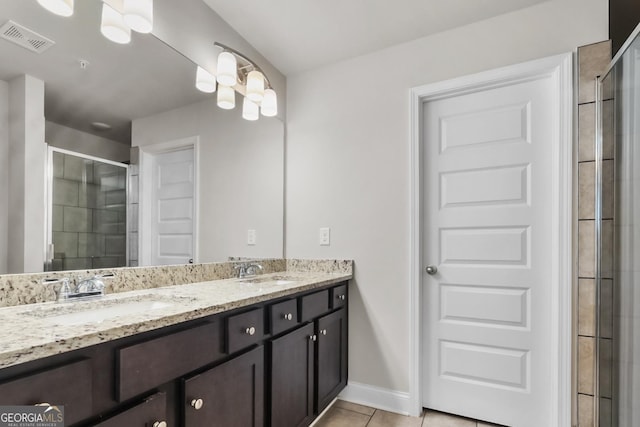 bathroom with vanity, a shower with door, and tile patterned flooring