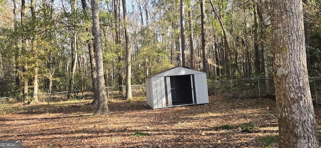 view of shed featuring a fenced backyard and a wooded view