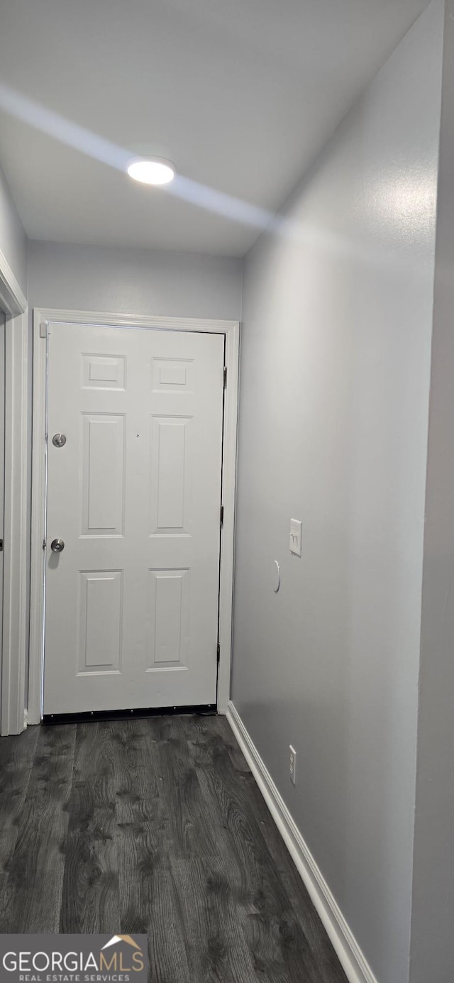 doorway to outside with dark wood-style flooring and baseboards