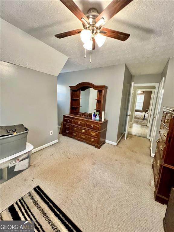 carpeted bedroom featuring a textured ceiling and ceiling fan