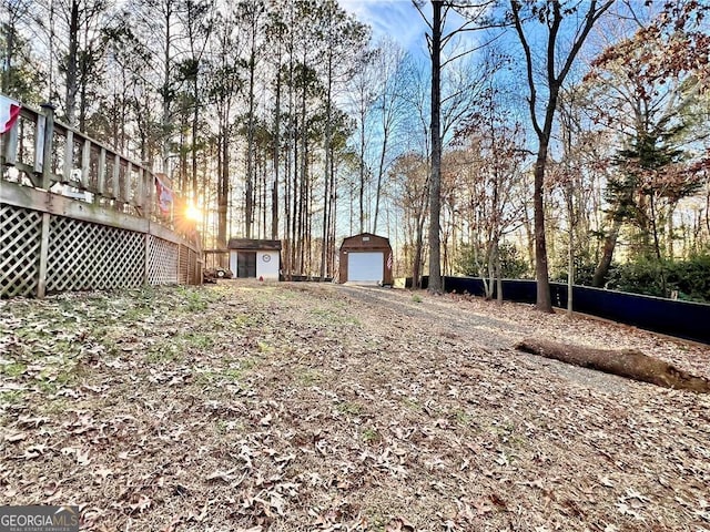 view of yard with a storage shed, a garage, and a deck