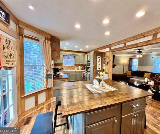 kitchen with butcher block counters, light hardwood / wood-style flooring, a center island, and appliances with stainless steel finishes