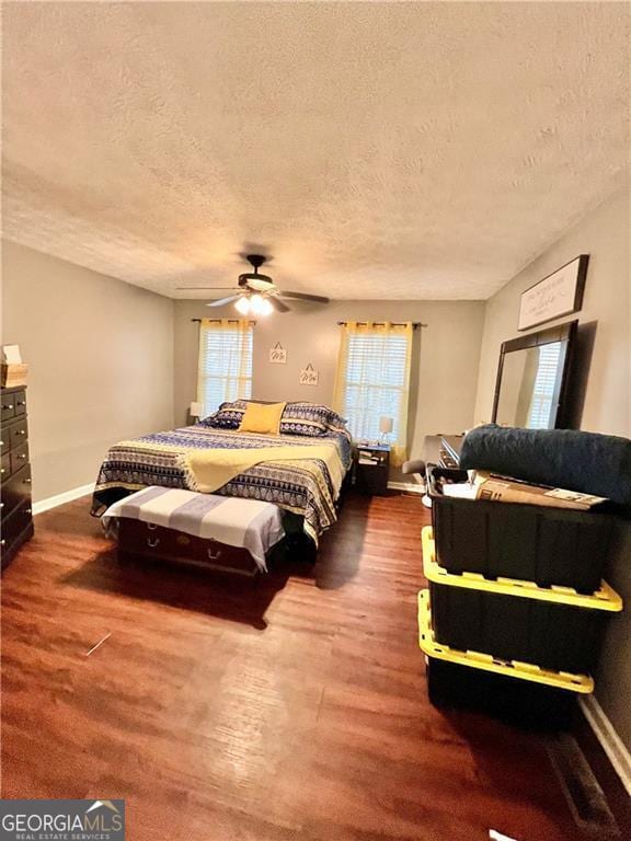 bedroom featuring ceiling fan, hardwood / wood-style floors, and a textured ceiling