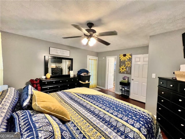 bedroom featuring a textured ceiling, dark hardwood / wood-style floors, and ceiling fan