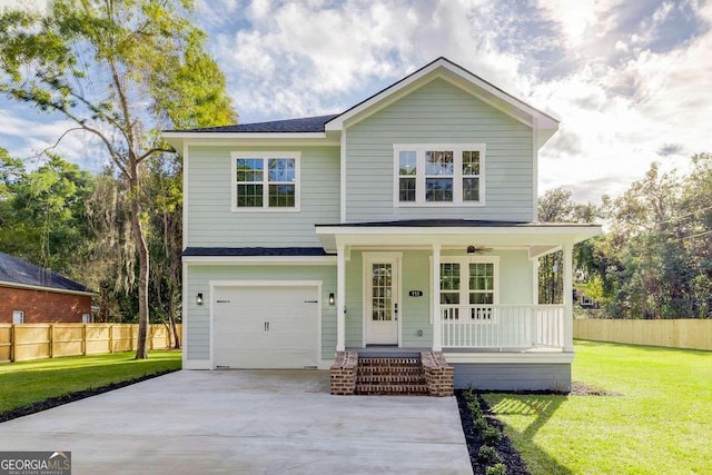 view of front of house featuring a garage, a front yard, and covered porch