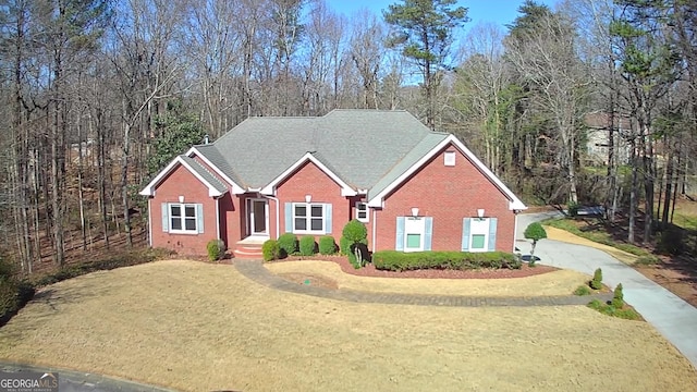 view of front facade with a front lawn, concrete driveway, and brick siding