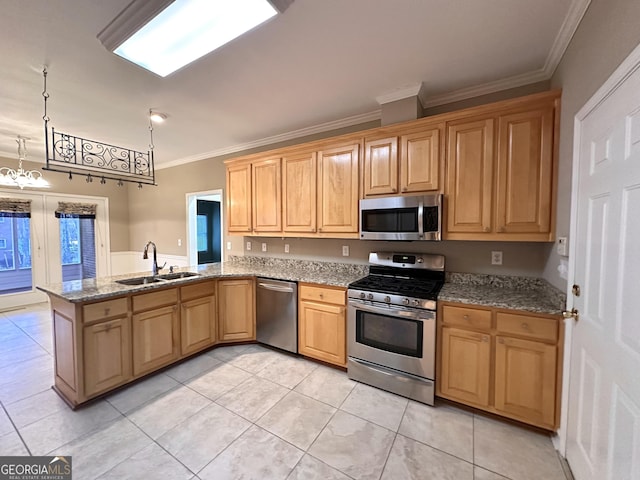 kitchen with crown molding, stainless steel appliances, a sink, light stone countertops, and a peninsula