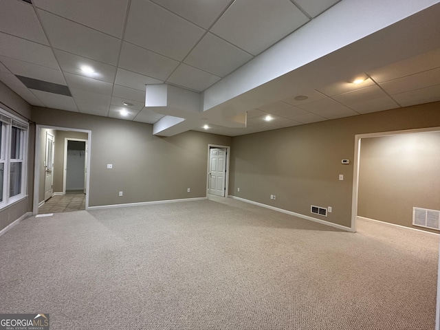 empty room featuring light carpet, a paneled ceiling, visible vents, and baseboards