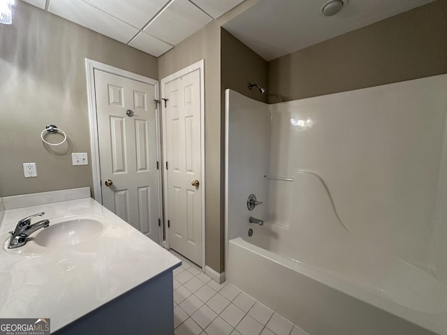 full bathroom featuring  shower combination, a drop ceiling, vanity, and tile patterned floors