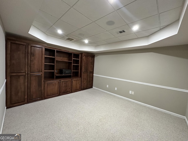 interior space with a tray ceiling, carpet, visible vents, and baseboards