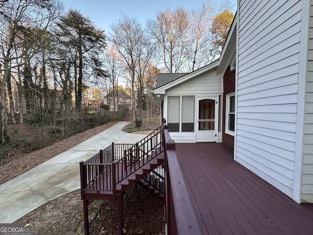 wooden deck featuring a sunroom and stairway