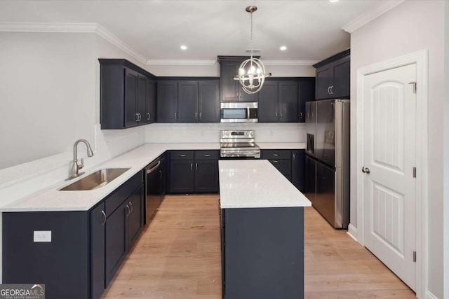 kitchen with a kitchen island, pendant lighting, sink, stainless steel appliances, and light wood-type flooring