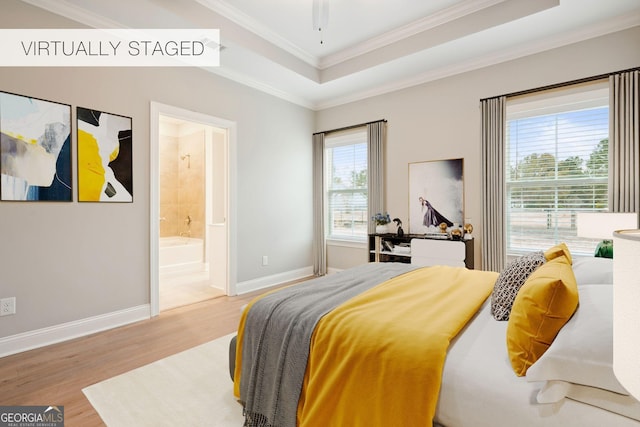 empty room with crown molding, a tray ceiling, light hardwood / wood-style flooring, and ceiling fan