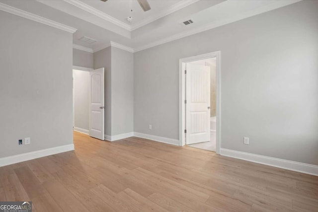 unfurnished room featuring ceiling fan, ornamental molding, a tray ceiling, and light hardwood / wood-style flooring