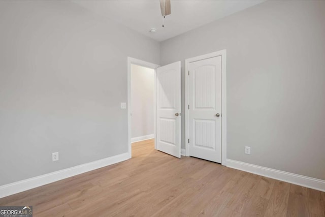 unfurnished bedroom with ceiling fan and light wood-type flooring