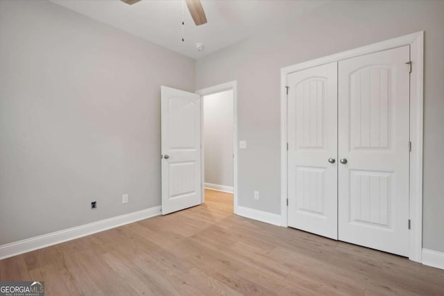 unfurnished bedroom with ceiling fan, a closet, and light wood-type flooring