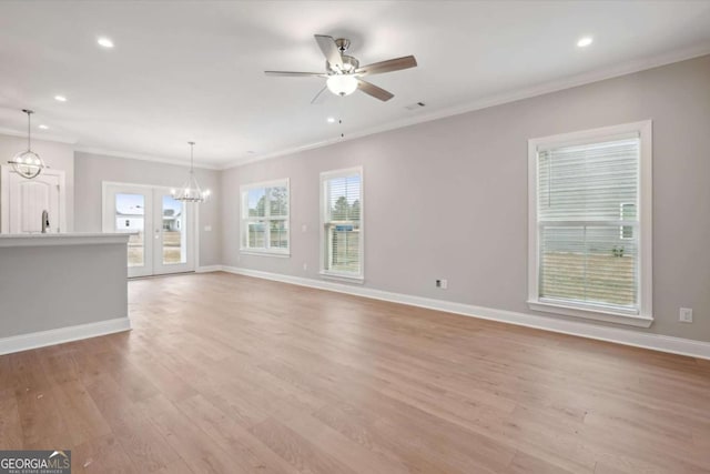 interior space featuring ornamental molding, ceiling fan with notable chandelier, and light hardwood / wood-style flooring