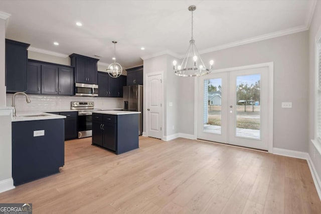 kitchen featuring sink, a center island, hanging light fixtures, light wood-type flooring, and appliances with stainless steel finishes