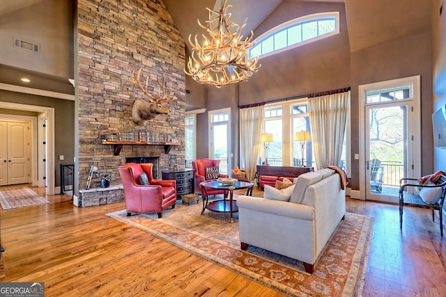 living room featuring hardwood / wood-style floors, a stone fireplace, and high vaulted ceiling