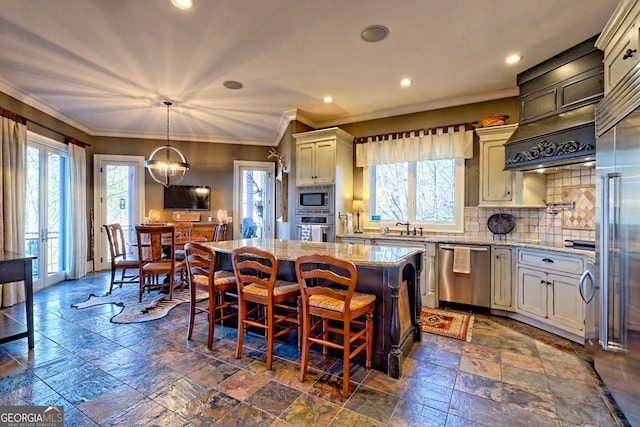 kitchen with a kitchen island, backsplash, hanging light fixtures, stainless steel appliances, and light stone countertops