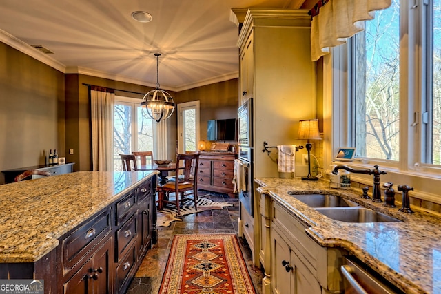 kitchen with sink, appliances with stainless steel finishes, dark brown cabinetry, light stone countertops, and decorative light fixtures