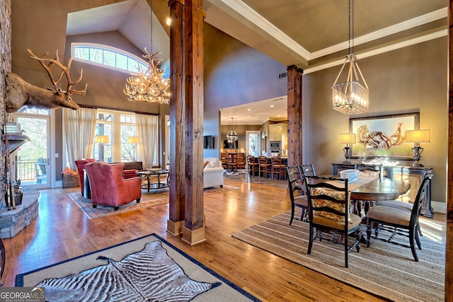 dining area featuring crown molding, a chandelier, and hardwood / wood-style flooring