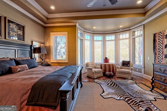 bedroom with multiple windows, wood-type flooring, and crown molding