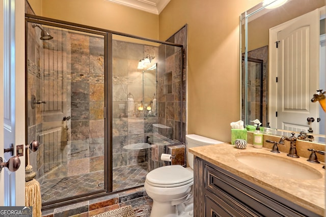 bathroom with crown molding, vanity, toilet, and a shower with door