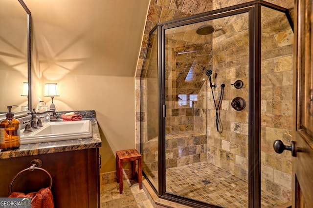 bathroom with vanity, vaulted ceiling, and walk in shower