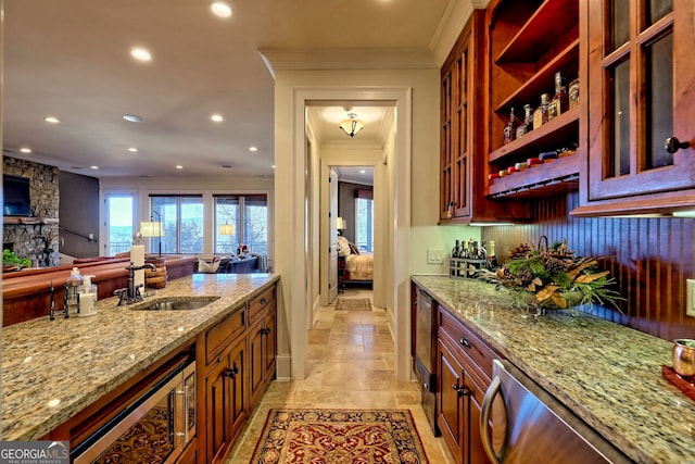 kitchen featuring ornamental molding, sink, and light stone counters