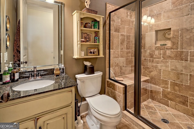 bathroom featuring vanity, an enclosed shower, and toilet