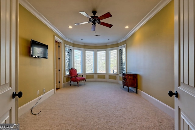 living area with ceiling fan, ornamental molding, and light carpet