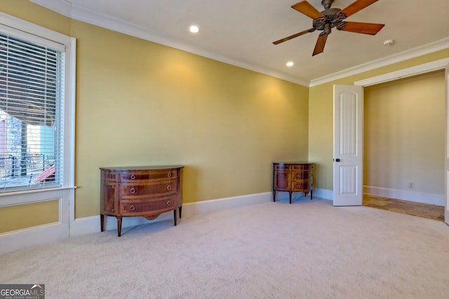 living area with crown molding, light colored carpet, and ceiling fan