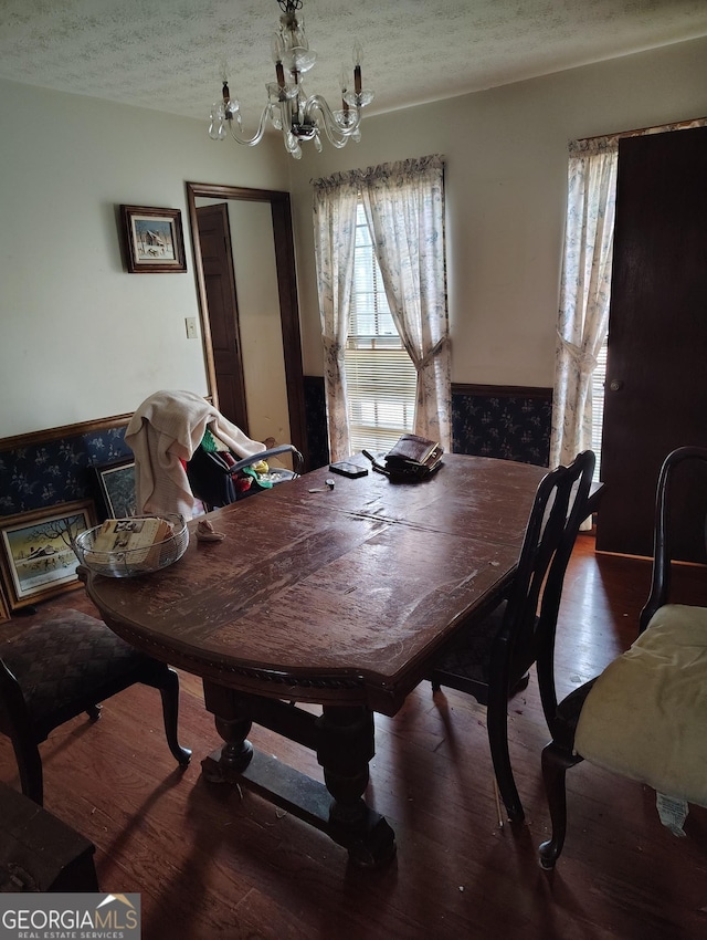 dining room featuring hardwood / wood-style floors, a textured ceiling, and a chandelier