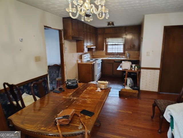 dining room featuring dark hardwood / wood-style flooring, sink, a textured ceiling, and a chandelier