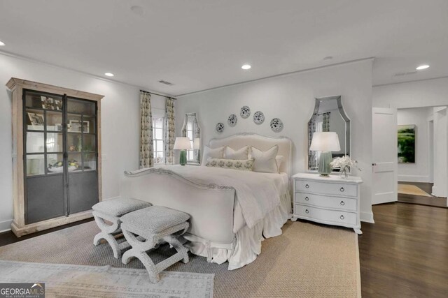 bedroom with connected bathroom and dark hardwood / wood-style floors