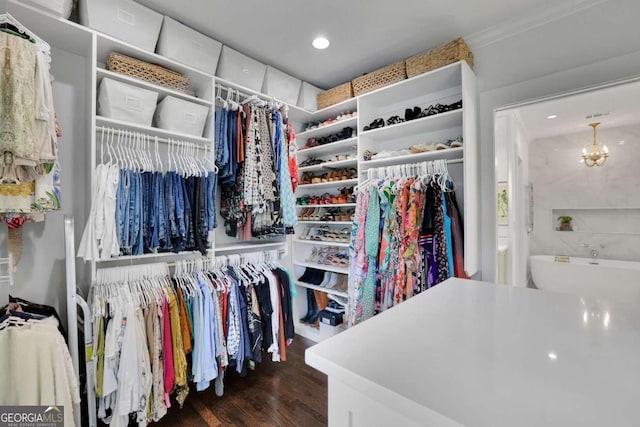 spacious closet featuring dark wood-type flooring and a chandelier