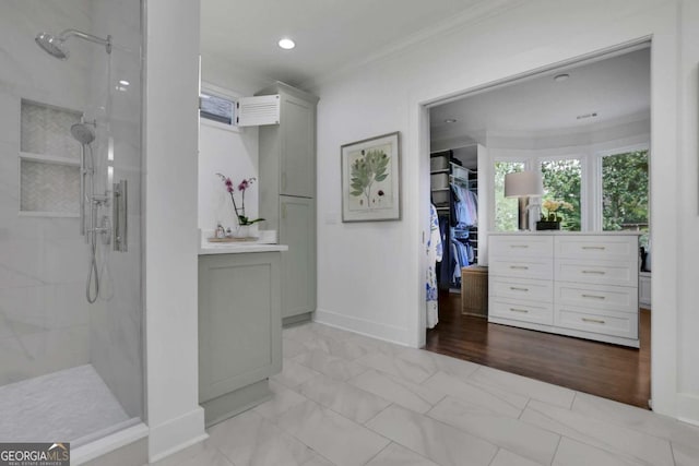 bathroom featuring crown molding and a tile shower