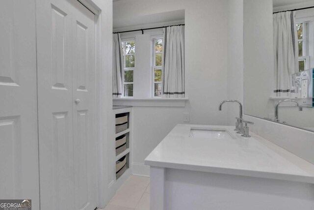 bathroom featuring tile patterned floors, a healthy amount of sunlight, toilet, and vanity